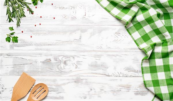 میز چوبی سفید با رومیزی سبز و وسایل آشپزی پوشیده شده است نمای از بالا رومیزی خالی برای مونتاژ محصول فضای خالی برای متن شما