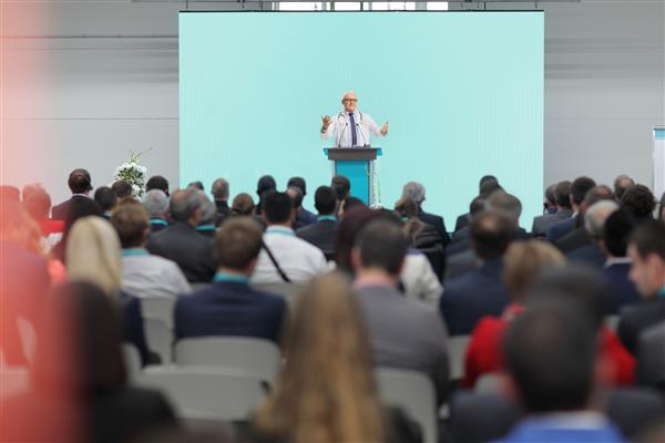 دکتر بالغ در حال سخنرانی روی صحنه در یک کنفرانس در مقابل حضار