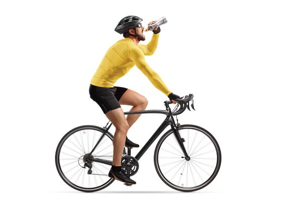 عکس نمایه یک ورزشکار مرد در حال دوچرخه سواری و نوشیدن از یک بطری جدا شده در پس زمینه سفید