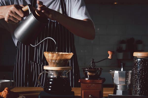 مفهوم کافی‌شاپ باریستای حرفه‌ای قهوه را با استفاده از chemex بر روی قهوه‌ساز و کتری قطره‌ای آماده می‌کند روش های جایگزین برای دم کردن قهوه