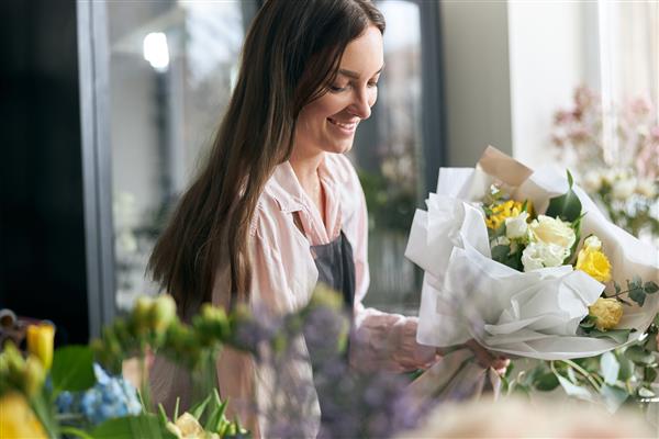 باغبان در گل فروشی دسته گلی برای تعطیلات درست می کند فروشگاه گل سبک زندگی ترکیب گل زیبا جزئیات نزدیک
