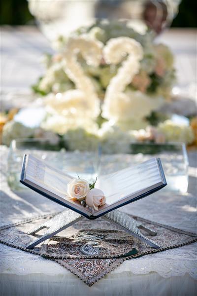 مجموعه کتاب شعر روی میز تزئین شده برای مراسم عروسی ایرانی