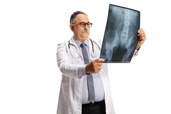 پزشک مرد بالغ در حال بررسی اسکن اشعه ایکس جدا شده در پس‌زمینه سفید