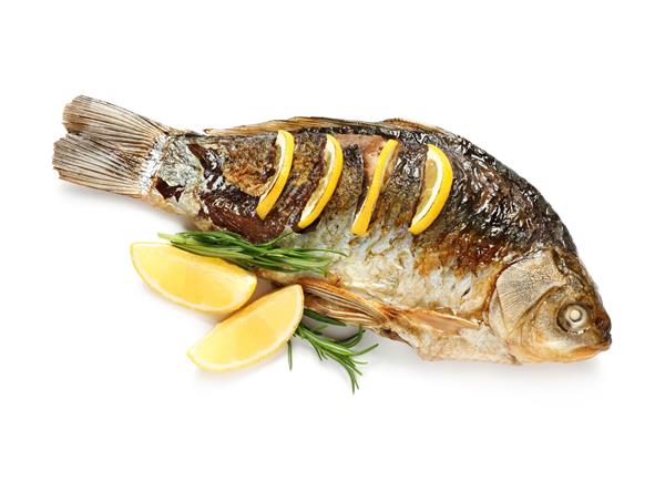 ماهی کپور برشته خانگی خوشمزه با رزماری و لیمو در زمینه سفید نمای بالا ماهی رودخانه