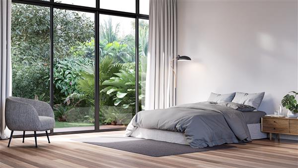 اتاق خواب مدرن با نمای باغ به سبک گرمسیری رندر سه بعدی اتاق ها دارای کف چوبی هستند با تخت پارچه ای خاکستری تزئین شده اند درهای کشویی بزرگ مشرف به تراس چوبی و باغ سبز است