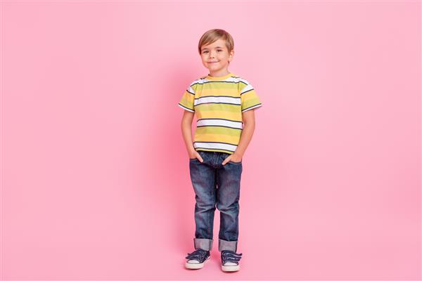 عکس کامل بدن از جیب‌های دستی پسر کوچک شاد مثبت و شاد که روی پس‌زمینه صورتی جدا شده است