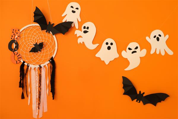 ارواح خفاش ها و یک شکارچی رویا با تار عنکبوت روی پس زمینه نارنجی یک مفهوم هالووین است فضای کپی