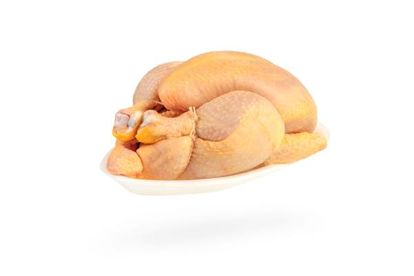 مرغ ذرت خام جدا شده در پس زمینه سفید لاشه مرغ در یک سینی پلاستیکی سفید بسته بندی می شود مرغ گوشت زرد ذرت را تغذیه می کند