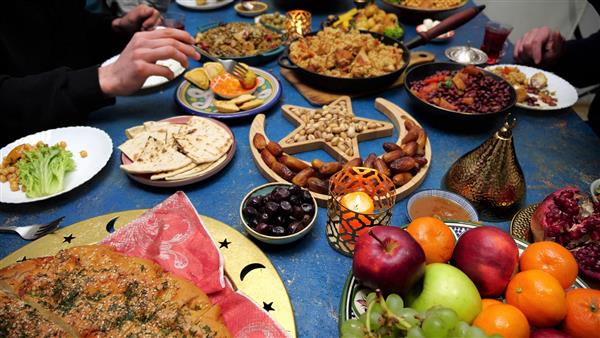 عید افطار رمضان خانواده مسلمان در خانه شام می خورند سفره با غذاهای سنتی جشن های عید سعید فطر
