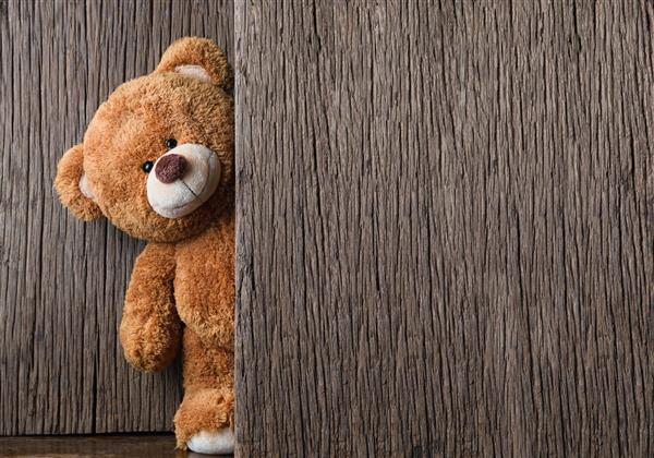 خرس عروسکی زیبا روی پس زمینه چوبی قدیمی با فضای کپی