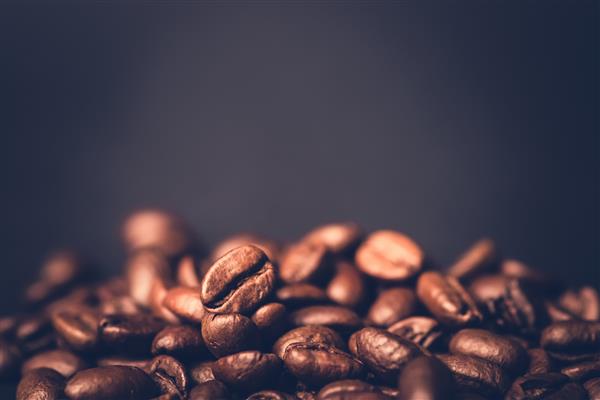 دانه های قهوه بو داده قهوه ای دانه در زمینه تیره اسپرسو تیره معطر نوشیدنی کافئین سیاه نزدیک به موکا انرژی جدا شده ماده کاپوچینو
