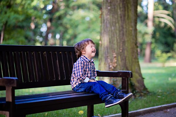 پسر بچه ناراحتی که در فضای باز گریه می کند کودک نوپا در پارک عصبانی می شود