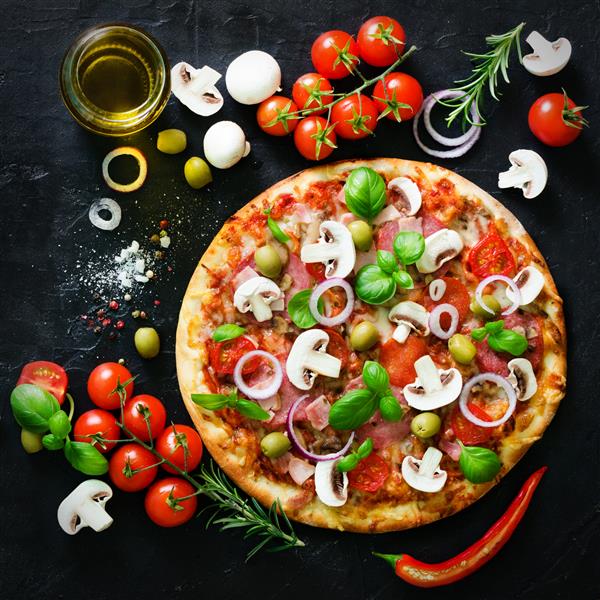 مواد غذایی و ادویه برای پخت قارچ گوجه فرنگی پنیر پیاز روغن فلفل نمک ریحان زیتون و پیتزای خوشمزه ایتالیایی در زمینه بتونی سیاه Copyspace نمای بالا