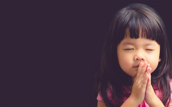 دختر کوچک در حال نماز صبح دست دختر کوچک آسیایی در حال دعا دستهای جمع شده در مفهوم دعا برای ایمان معنویت و مذهب مشکی