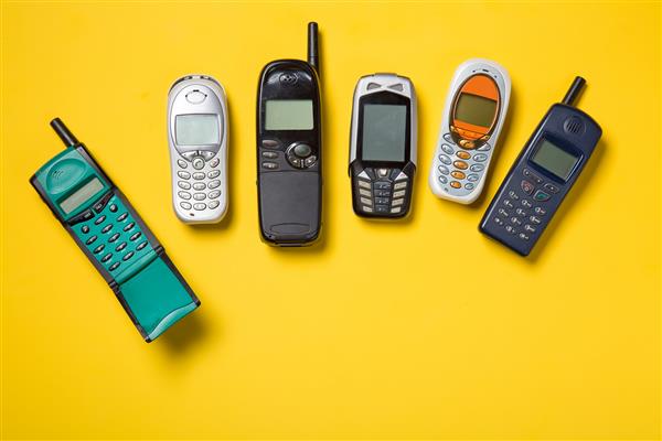 تلفن های همراه قدیمی در پس زمینه زرد