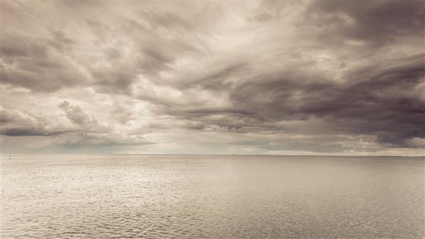عکس ایده آل مینیمالیستی از آب دریا و آسمان افقی در طول روز ابری مفهوم زیبایی طبیعت