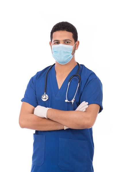 پرتره یک دکتر خوش تیپ با اسکراب با گوشی پزشکی که با اطمینان ایستاده و ماسک به سر دارد جدا شده در پس زمینه سفید