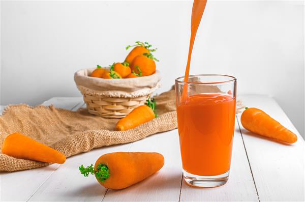 آب هویج در یک لیوان شفاف ریخته می شود