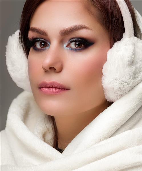 چهره زن زیبای ایرانی در پوشش زمستانی با گوشگیر و لباس پشمی سفید