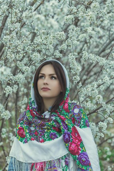 دختر ایرانی در لباس محلی و منظره ای پرشکوفه