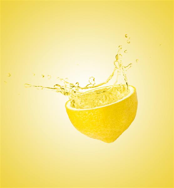 پاشش آب لیمو جدا شده در زمینه زرد