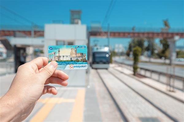 18 مه 2022 آنتالیا ترکیه دست مسافری که کارت آنتالیا را برای پرداخت بدون تماس و بدون نقد برای سیستم حمل و نقل شهری مدرن آنترا تراموا در شهر در دست دارد