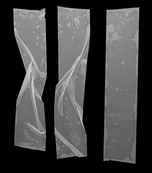 مجموعه ای از نوارهای چسب شفاف یا نوارهای چسب ایزوله شده بر روی پس زمینه سیاه تکه های چسبناک پلاستیکی مچاله شده عکس ماکرو واقعی