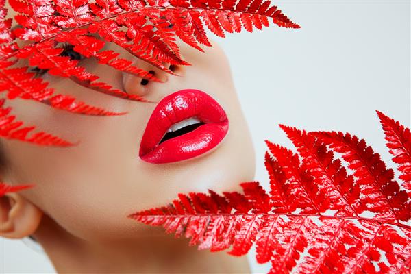زنی با لب های قرمز حسی و سرخس دهان زن با لب قرمز زن لب قرمز پرتره زن با آرایش روشن برق لب