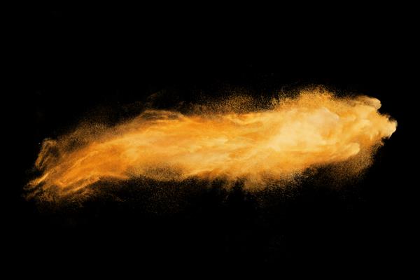طرح انتزاعی انفجار ابر پودر نارنجی در پس زمینه تیره