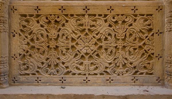 زیور آلات حک شده بر روی دیوارها در جیسالمر هند بافت سنگ ماسه الگوی تزئینی به سبک شرقی بافت دیوار حک شده پس زمینه