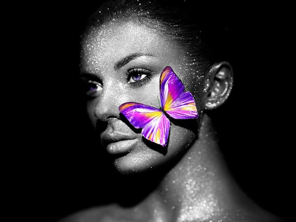 زن مدل مد با درخشش های روشن و چراغ هایی که در استودیو ژست گرفته است پرتره زن زیبای سکسی با پروانه آرایش براق طرح هنری عکاسی سیاه و سفید