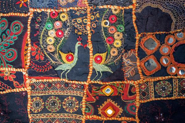 دهلی هند - 5 اکتبر تکه تکه‌ای قدیمی با جزئیات قومی پرندگان و طرح‌های گل روی بافت پتوی قدیمی در 5 اکتبر 2017 پنبه تا 4000 سال قبل از میلاد در هند اهلی شد