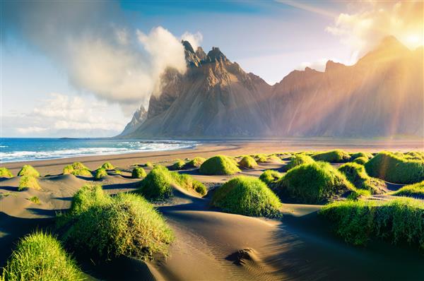 منظره تابستانی چشمگیر از تپه های شنی سبز در سرچشمه Stokksnes با کوه Vestrahorn در پس زمینه جنوب شرقی ایسلند اروپا پس زمینه مفهوم زیبایی طبیعت