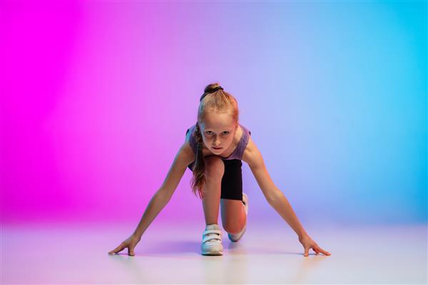 سالم دختر نوجوان دونده حرفه ای دویدن در حال حرکت حرکت ایزوله شده روی پس زمینه صورتی-آبی گرادیان در نور نئون مفهوم ورزش حرکت انرژی و پویا سبک زندگی سالم
