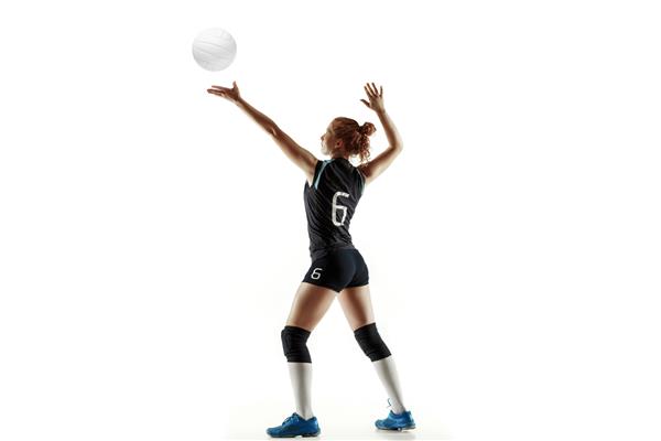 بازیکن زن جوان والیبال جدا شده در پس زمینه سفید استودیو زنی با تجهیزات ورزشی و کفش یا کفش ورزشی در حال آموزش و تمرین مفهوم ورزش سبک زندگی سالم حرکت و حرکت