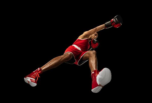 بوکسور حرفه ای جوان آفریقایی-آمریکایی در حال عمل حرکت ایزوله شده روی دیوار سیاه از پایین نگاه کنید مفهوم ورزش حرکت انرژی و پویا سبک زندگی سالم آموزش تمرین
