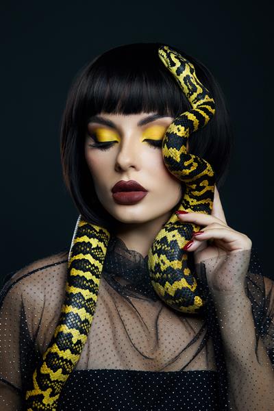 زن زیبا مدل موی کوتاه مار زرد پیتون روی گردنش یک مار زرد روی شانه های یک دختر آرایش سایه چشم زرد زیبایی رژ لب بورگوندی تیره