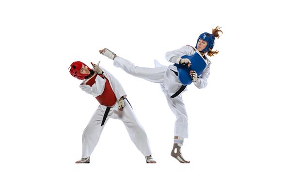 پرتره تمام قد از دو ورزشکار حرفه ای تکواندو که جدا شده روی پس زمینه سفید می جنگند