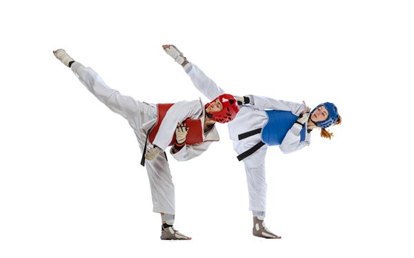 پرتره تمام قد از دو ورزشکار حرفه ای تکواندو که جدا شده روی پس زمینه سفید می جنگند