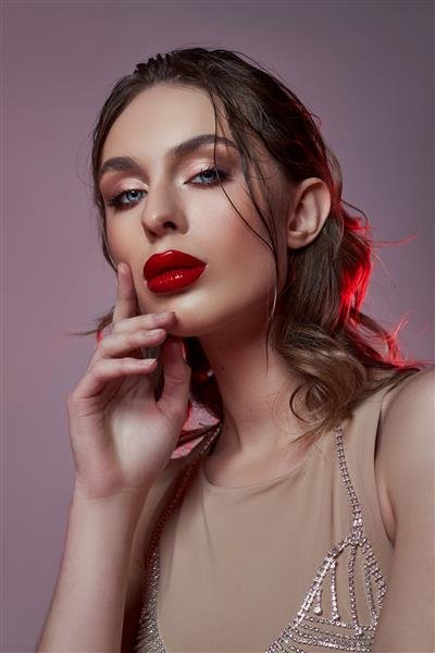 زن سکسی زیبا با لباس بدن بژ جواهرات سوتین ساخته شده از بدلیجات زن بدن کامل آرایش قرمز روشن موهای فر زیبا