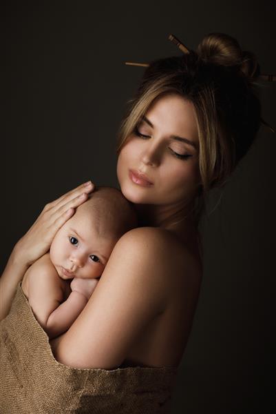 پرتره مادر زیبا و نوزاد کوچکش در گونی پیچیده شده است
