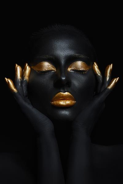 زن زیبایی که با رنگ پوست مشکی نقاشی شده است پلک های آرایش طلایی لب ناخن های نوک انگشتان با رنگ طلایی آرایش طلایی حرفه ای