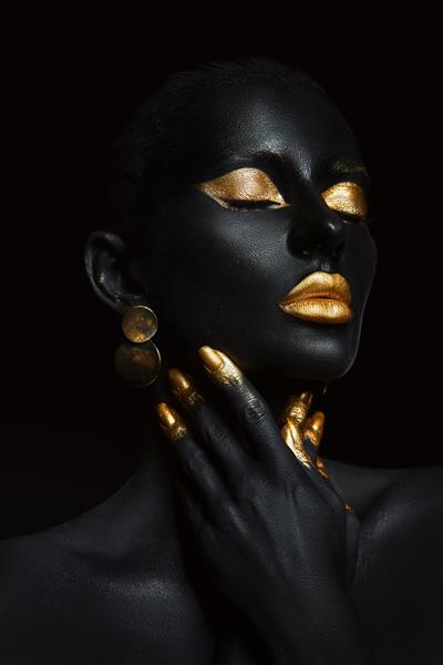 زن زیبایی رنگ شده با رنگ پوست مشکی هنر بدن آرایش طلایی لب پلک انگشتان ناخن در رنگ طلایی آرایش طلایی حرفه ای