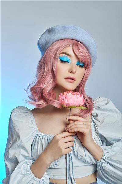 زن عاشقانه با موهای صورتی با کلاه آبی روی سر یک زن فرانسوی با گل رز در دستانش آرایش آبی روی پلک های یک زن جوان