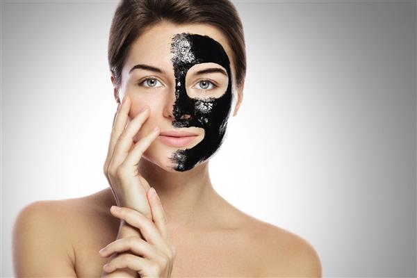زنی با ماسک سیاه پاک کننده عمیق روی صورتش