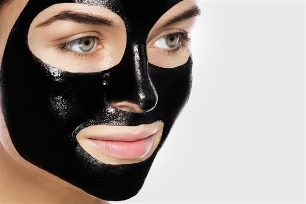 زنی با ماسک سیاه پاک کننده عمیق روی صورتش