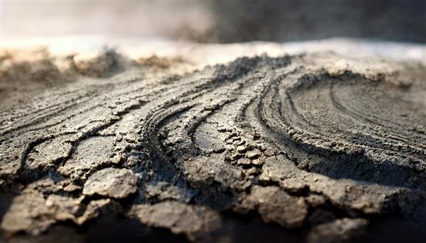 خودرو خاکستری را در خاک مرطوب در پس‌زمینه تار نشان می‌دهد