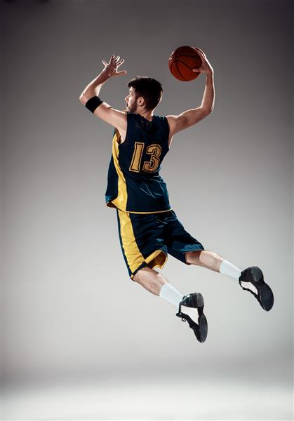 پرتره تمام طول یک بسکتبالیست با توپ