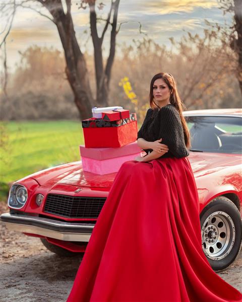 زن زیبا با دامن قرمز نشسته روی ماشین قرمز و جعبه هدیه عکاسی مادلینگ در ترکیه