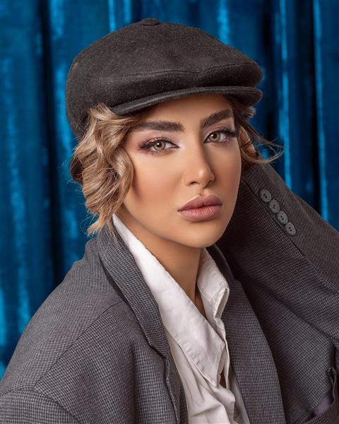 مدل زن ایرانی با موها روشن با کت و کلاه مردانه خاکستری